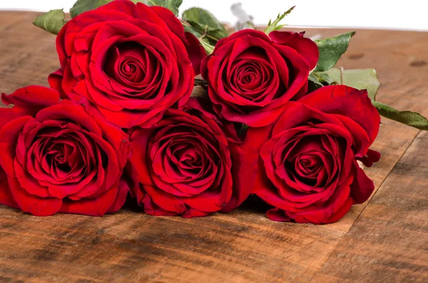 Ahşap bir masada kırmızı güller — Stok fotoğraf