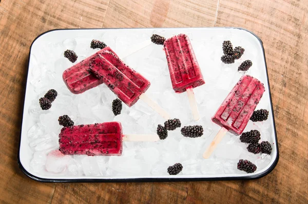 Frozen berry pops on tray of ice — Stock Photo, Image