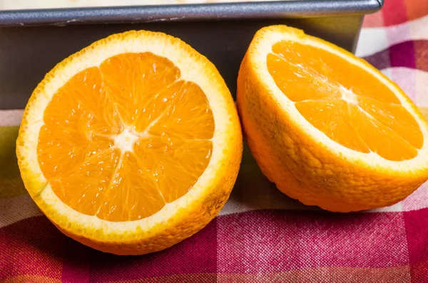 Naranjas cortadas por la mitad sobre tela —  Fotos de Stock