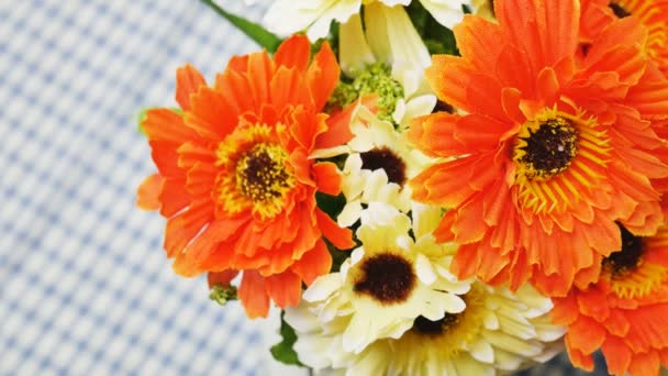 Flores artificiales naranjas en la mesa de comedor — Vídeo de stock