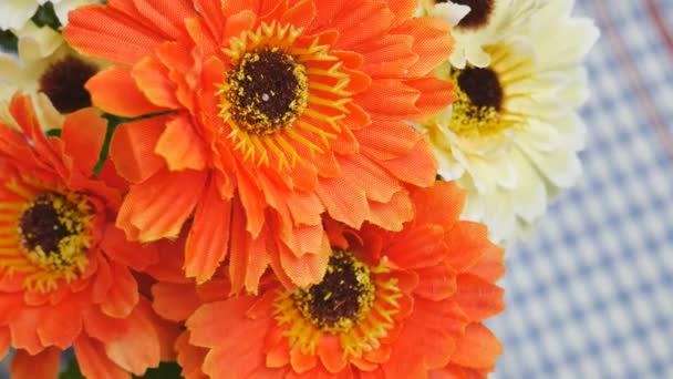 Oranje kunstbloemen op de eettafel — Stockvideo