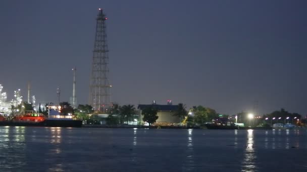 Scène nocturne de l'usine industrielle pétrolière et raffinerie avec rivières — Video