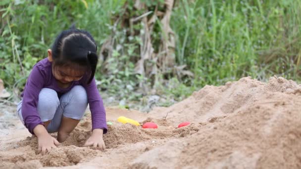 Азиатский ребенок будет играть в песок — стоковое видео