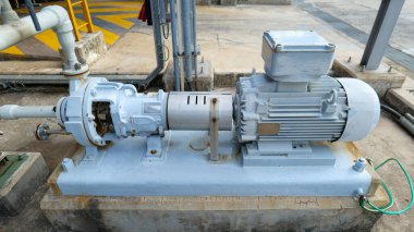 Elektrik enerjisini mekanik enerjiye dönüştürmek için bir endüstriyel fabrikaya indüksiyon motoru, boru hatları aracılığıyla sıvı materyallerin taşınması için pompa ile birleştir, güvenilir endüstriyel ekipman ve işlem işlemini temsil eder.