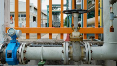 Büyük bir metal boru hattına kurulmuş manüel bir valf, endüstriyel bir fabrikada hassasiyet, güvenlik ve operasyonel güvenilirliği temsil eden sıvı akışını kontrol eder..