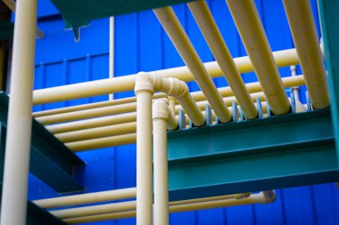 Fabrika içindeki sarı kimyasal boru hatları düzenli ve düzenli bir şekilde düzenlenerek modern endüstriyel kimyasal işleme ve altyapı tasarımında hassasiyet, güvenlik ve verimliliği temsil etmektedir..