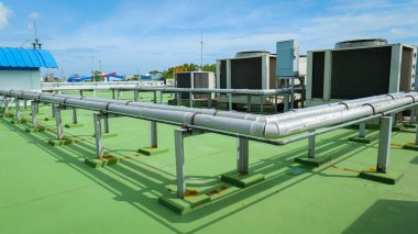 HVAC (Isıtma, Havalandırma ve Havalandırma) birimleri, hava ve hava kalitesi için hava kanalları ve endüstriyel havalandırma teknolojisini gösteren modern bir binanın çatısına kurulmuştur.