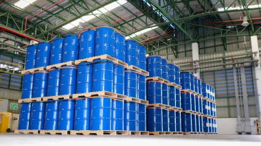 Depoda sayısız mavi çelik variller, variller, depoda yanıcı benzin varilleri, kimyasal depolama koridorları, istiflenmiş metal variller, yüksek riskli nakliye malları, endüstriyel güvenlik