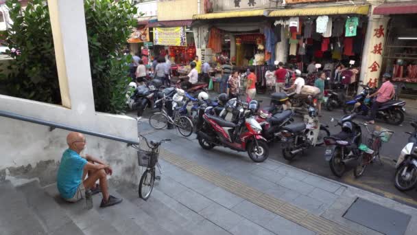 Старший сидит на лестнице возле утреннего рынка.. — стоковое видео
