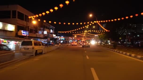 夜に赤い提灯で飾られた忙しい道路交通でドライブ. — ストック動画