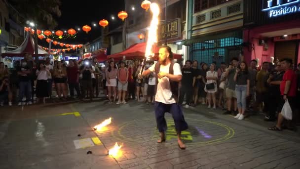 Ein Straßenmusiker spielt während miaohui ein Feuerschwert auf der Straße. — Stockvideo