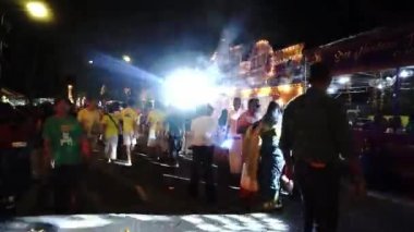 Takipçiler Thaipusam kutlamaları sırasında gece sokakta yürürler.