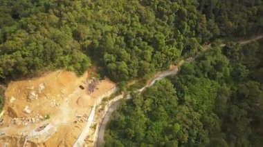 Asya ülkesindeki yeşil ormanın yanında hava manzaralı inşaat çalışmaları. Geliştirme sırasında ormanların yok edilmesi.