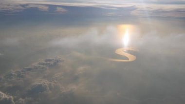 Arazi ve nehrin üzerindeki bulutun üzerindeki hava manzaralı güneş ışınları