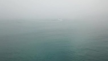 Hava görüntüsü Kaikoura, Güney Adası, Yeni Zelanda 'daki sisli denizde bir tekne kalkıyor..