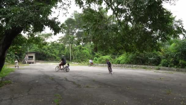 Les villageois font du vélo à découvert sur la route asphaltée. — Video