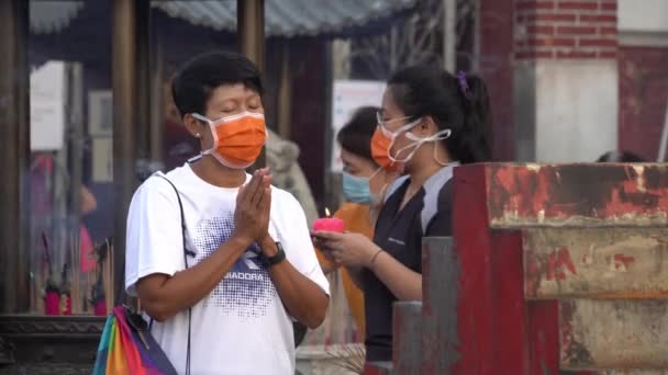 Čínští oddaní nosí masku během modlitby v čínském chrámu. — Stock video