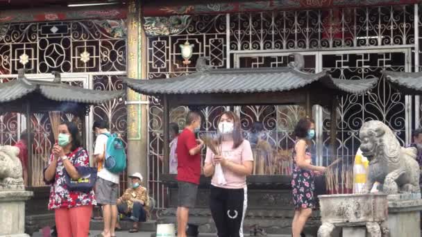 Les dévots chinois portent un masque facial pendant qu'ils prient au temple. — Video