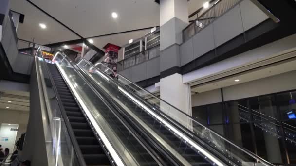 Una chica musulmana usa máscara facial en escaleras mecánicas en el complejo. — Vídeos de Stock