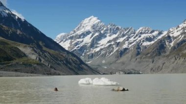 Bir adam Cook Dağı 'ndaki gölde yüzüyor..