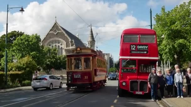 Tram passeren de rode dubbeldekker parkeren naast de weg in de buurt van het museum. — Stockvideo