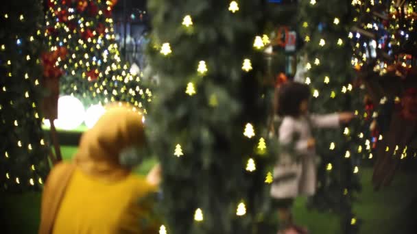 Müslüman Annenin Bulanık Odağı Noel Ağacı Etrafında Oynayan Kızının Fotoğrafını — Stok video