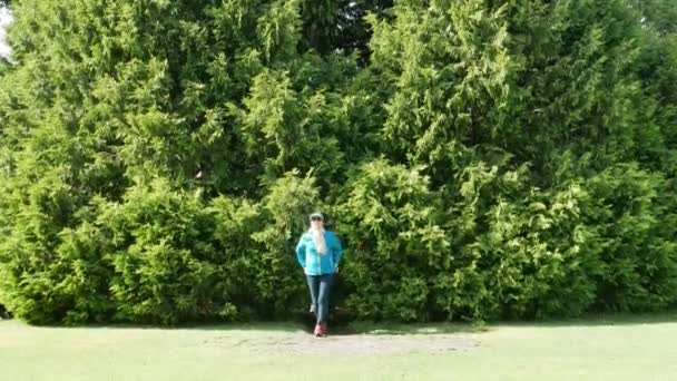 Asian tourist come out from the tree and bushes in botanical garden. — Stock Video