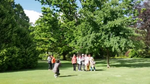 Aziatische vrouwen nemen foto bij de botanische tuin. — Stockvideo