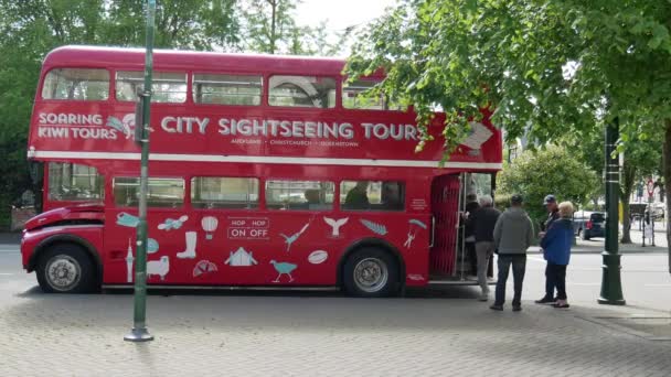 Turysta na pokładzie Rosnące Kiwi Tours czerwony dwupokładowy do zwiedzania. — Wideo stockowe