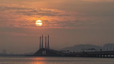 Penang Köprüsü 'ndeki sütunlardan sabah güneşi doğuyor..