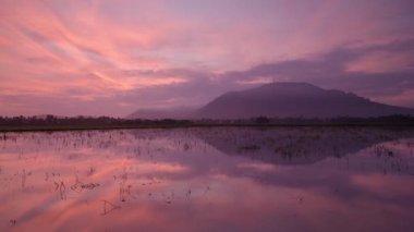 Zaman ayarlı gündoğumu yansıması Sudaki Bukit Mertajam Tepesi.