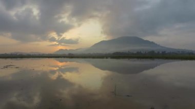 Çeltik tarlasında güzel bir gün doğumu görüntüsü yansıması olan Bukit Mertajam.
