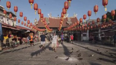 Georgetown, Penang / Malezya - 15 Şubat 2018: Çin Yeni Yılı boyunca tapınakta dua edenler. Fenerin gölgesi yerde sergilenir..