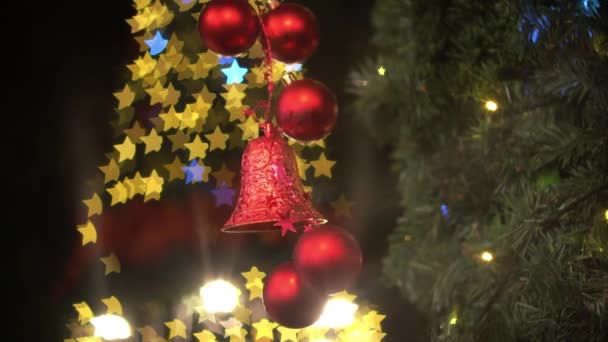 フォーカスクリスマスの装飾赤いボールと鐘を選択します カラフルな星ボケちらつき — ストック動画