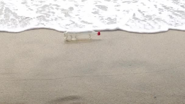 Delikatna Fala Rozpryskuje Plastikową Butelkę Plaży — Wideo stockowe