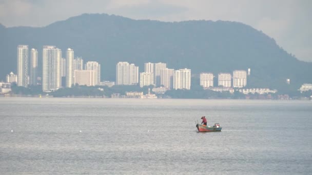 Pescatore raccogliere rete in mare. Lo sfondo è condominio a Penang Island. — Video Stock