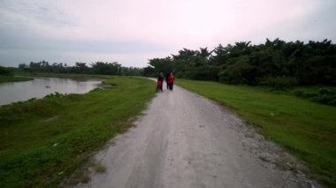 Malay ailesi bisiklet sürüyor ve açık havada yürüyor..