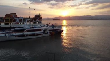 Eski feribot ve Butterworth terminalinde yeni sürat teknesi üzerinde uçan bir hava aracı.