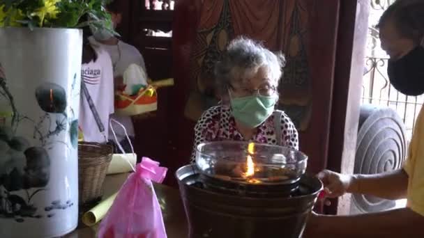 Femme chinoise avec masque verser l'huile dans le récipient — Video