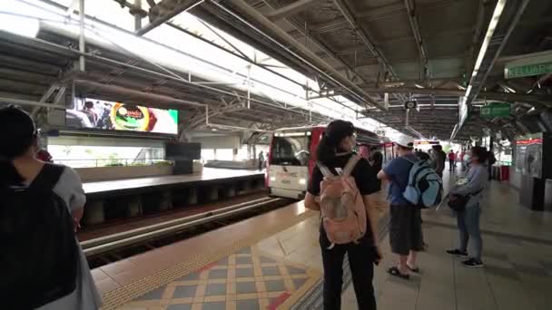 Folk bär mask vänta på ankomsten av LRT — Stockvideo