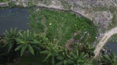 Havadan bakıldığında çöplük karanlık nehirde kapana kısılmış..