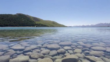 Zaman ayarlı berrak su Yeni Zelanda Tekapo Gölü 'nün altında görülebilir.
