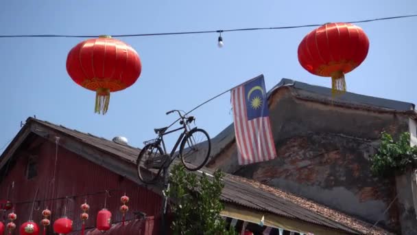 Antikes Fahrrad auf dem Dach mit Malaysia-Flagge. — Stockvideo