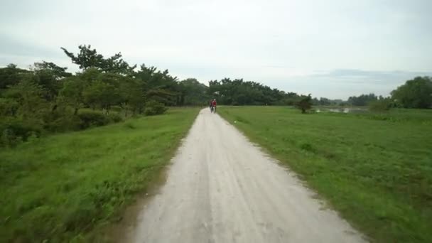 자전거타는 사람 이사는 마을의 시골 길 — 비디오
