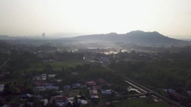 Sisli bir sabahta Malay kırsal köyünün üzerinde hava manzarası uçuşuyor