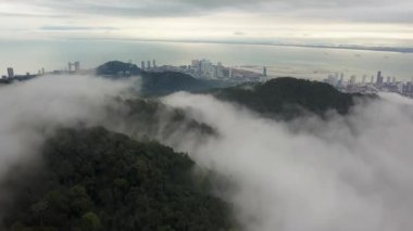 Alçak hareket eden bulutlar arasında Penang Tepesi 'nin üzerinden uç