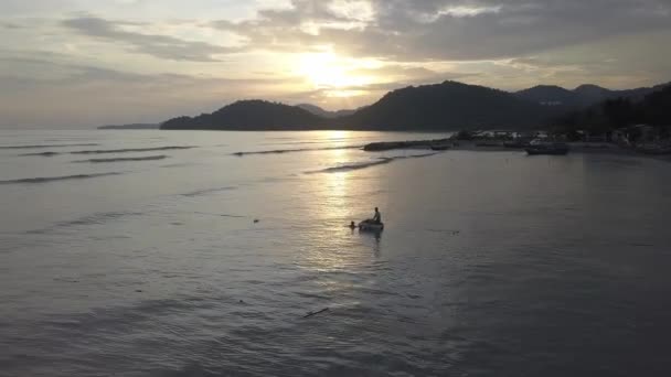 Pêcheur ramasser filet de pêche en mer pendant l'heure du coucher du soleil. — Video
