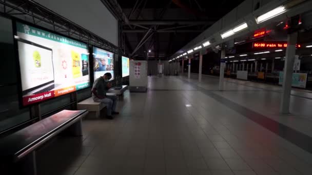 Un hombre sentado en la silla en la estación de LRT — Vídeos de Stock