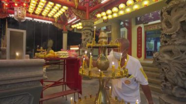 Çinli fanatikler maske takar. Mumu yak.