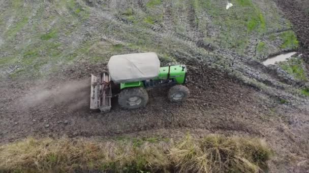 Luchtfoto groene trekker ploegen land — Stockvideo